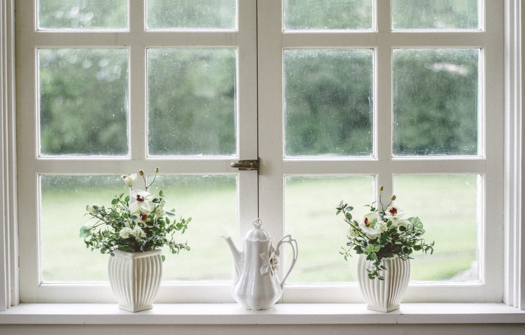 White window sill with fresh flowers in vases