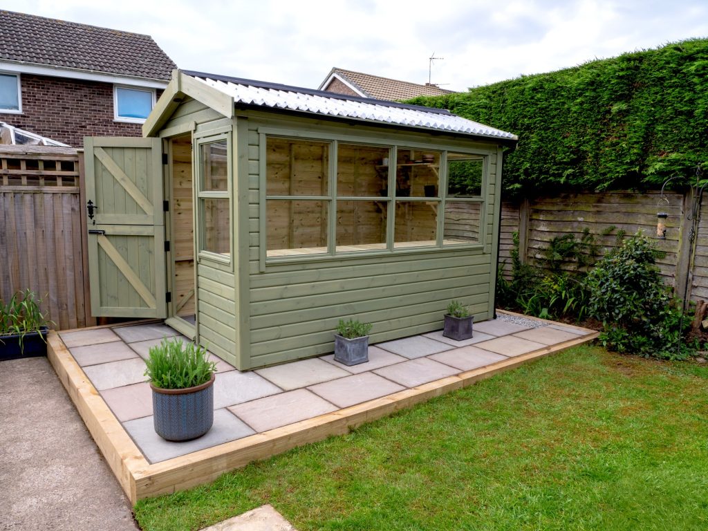 Green wooden shed in garden